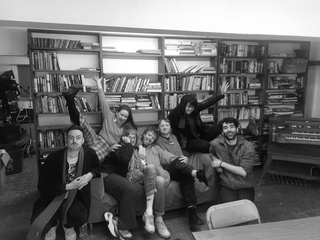 Praxis oragnisers letting loose on a couch in Rebel Reads after hard work at the AGM